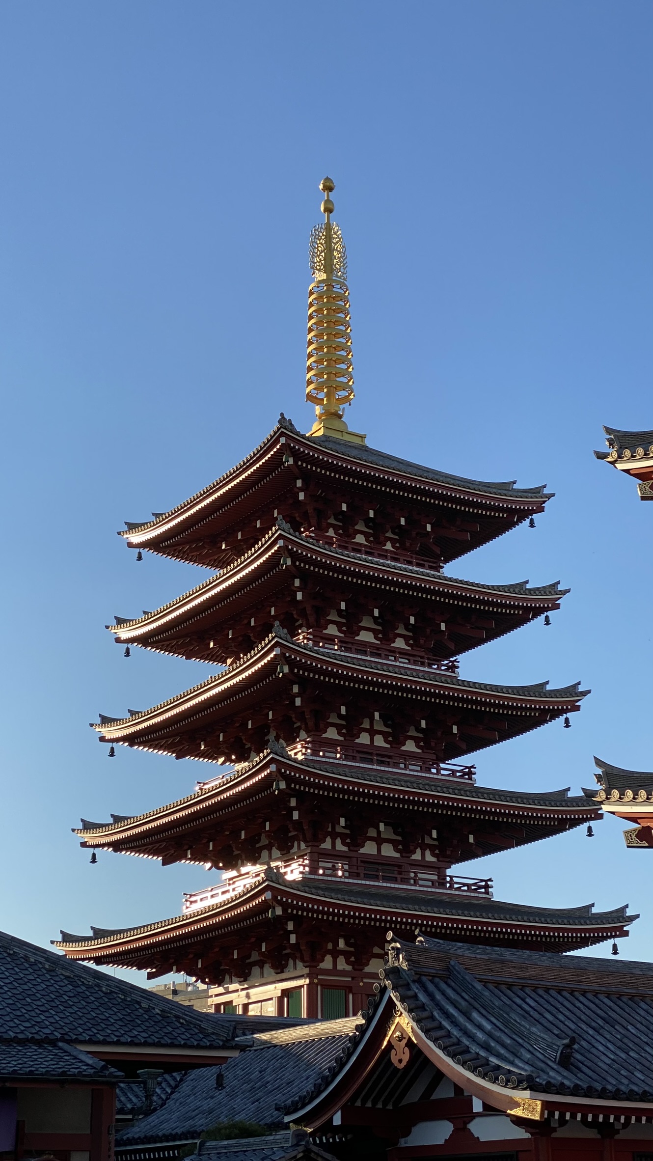 A red Japanese pagoda beneath a clear blue sky